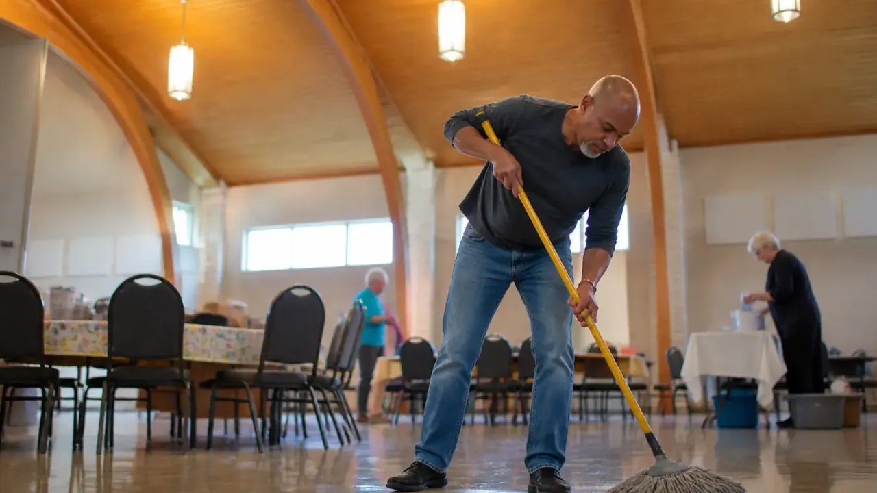 Volunteer counting folding chairs in a sanctuary, low wide angle
