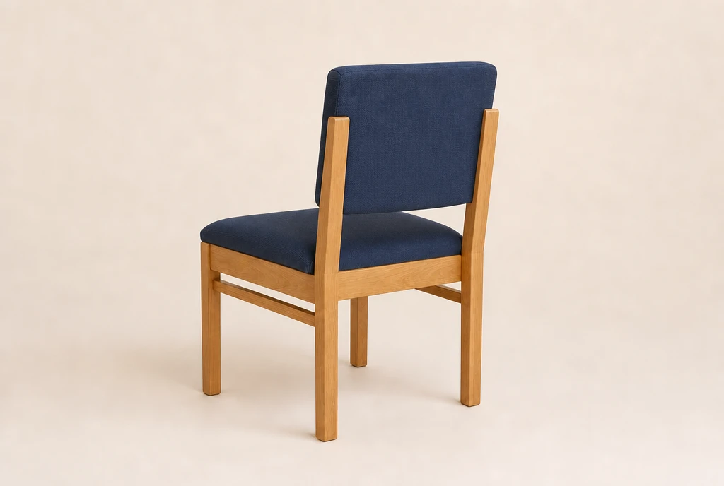 Warm honey-maple hardwood church chair concept with muted navy-blue woven fabric and no rear book rack